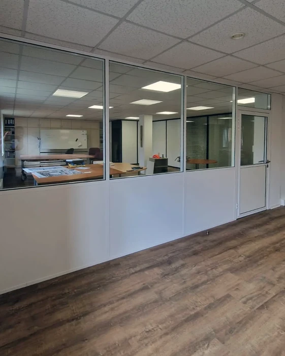 Bureau moderne avec cloison vitrée séparant deux espaces de travail
