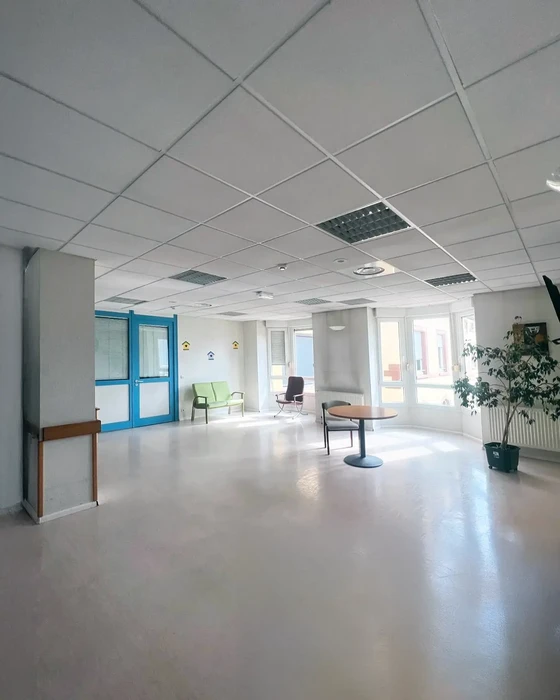 Couloir d'appartement moderne avec parquet en chêne massif, murs blancs et porte grise anthracite