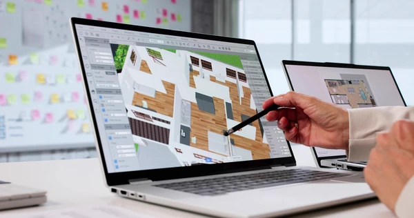 Deux personnes travaillent sur des plans d'architecture d'intérieur autour d'une table en bois