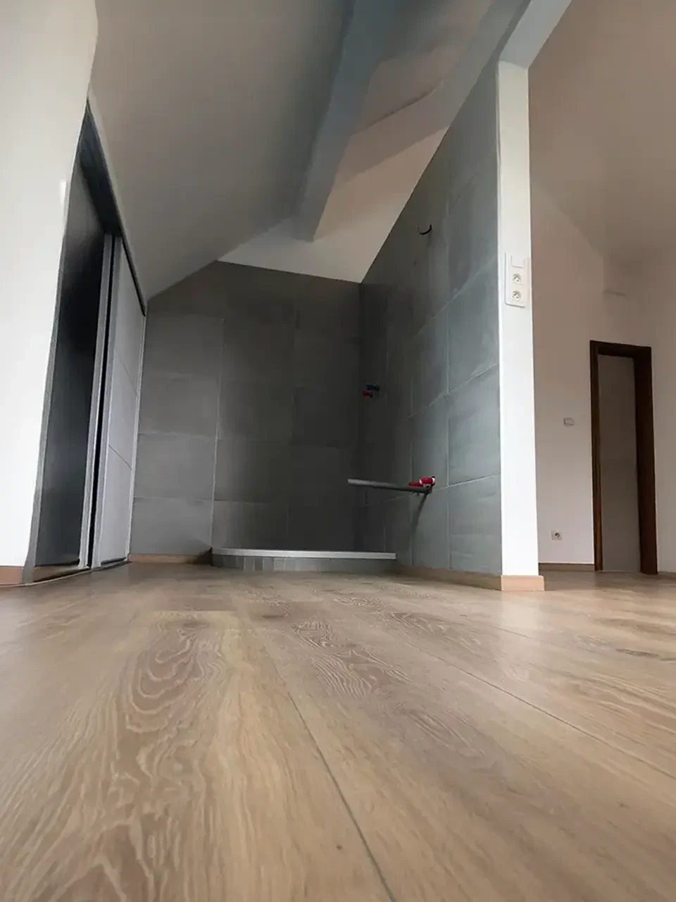 Couloir d'appartement rénové avec parquet en bois massif aux veines prononcées