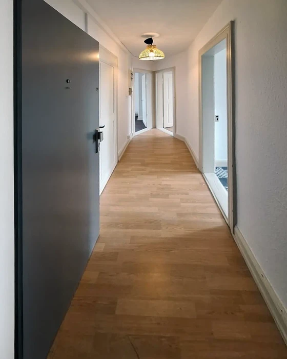 Ouvrier installant un parquet flottant dans une chambre en rénovation